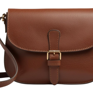 Ce sac en bandoulière en cuir marron chaud présente un design classique et intemporel avec une forme arrondie et un rabat à boucle dorée. La texture du grain est visible et raffinée, soulignant une finition artisanale de haute qualité sur un fond noir contrastant. C’est la pièce emblématique qui pourrait parfaitement incarner une collection de maroquinerie écoresponsable.