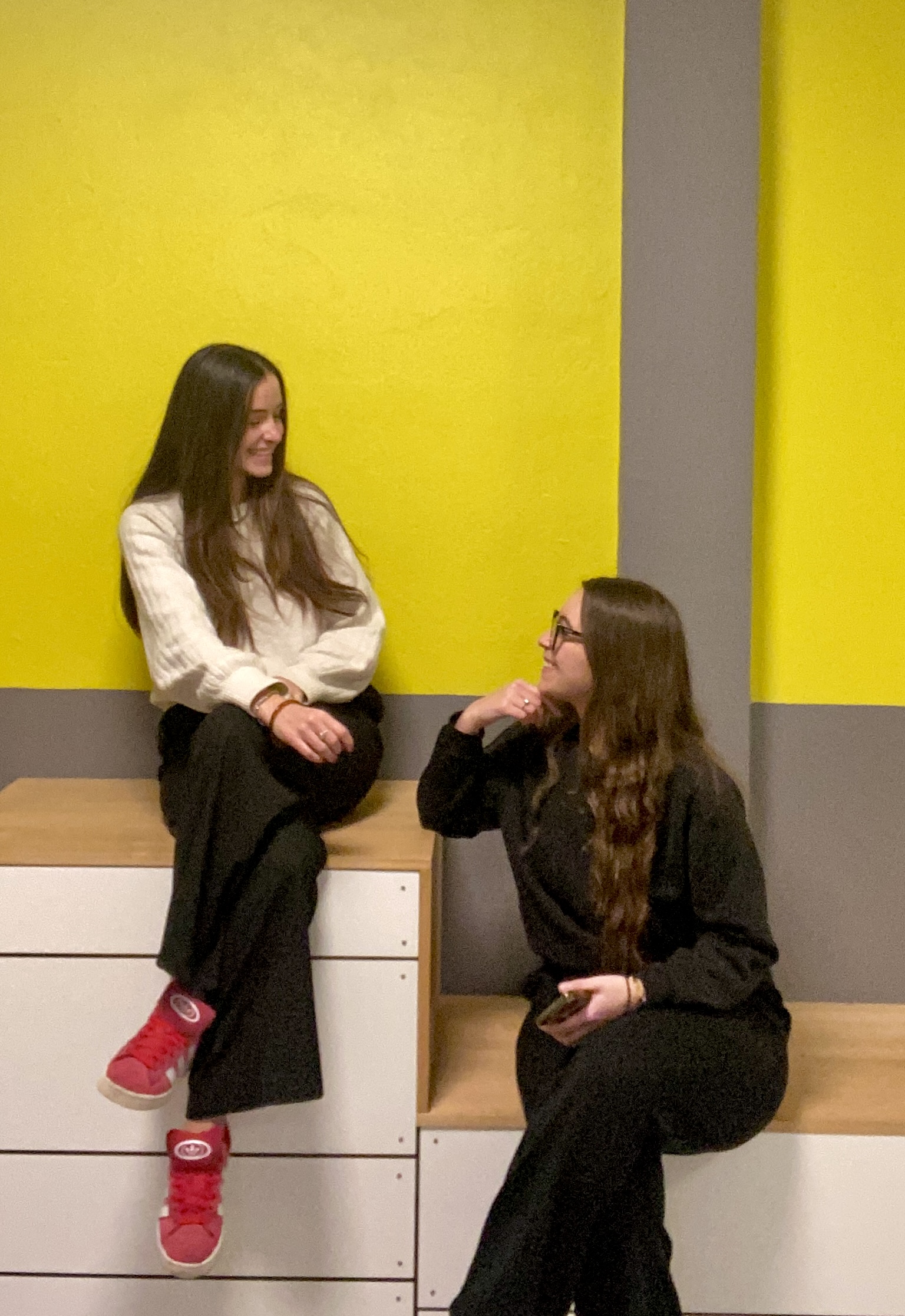 Photo de deux jeunes femmes assises sur un banc.